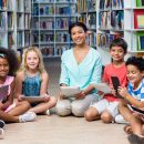 Teacher with children holding digital tablets