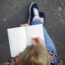 Student girl writing with a pencil in a notebook