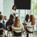 female-african-american-speaker-giving-presentation-in-hall-at-university-workshop_1