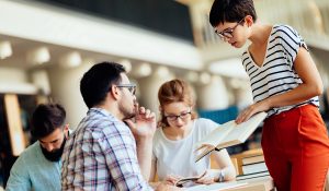 Group of college students studying at library