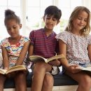 Group Of Multi-Cultural Children Reading On Window Seat