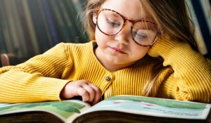 little-girl-wearing-eyeglasses-reading-a-story