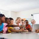 A,Teacher,Giving,Lesson,With,Tablet,Computer,In,Classroom